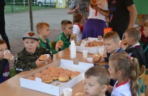 grupa dzieci przy stole jedzaca paczki