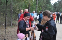 Dekorowanie zawodników medalami przez druhów strażaków