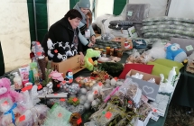 stoisko z ozdobami swiatecznymi, materacami, poduszkami, koldrami oraz dwie kobiety przy nim