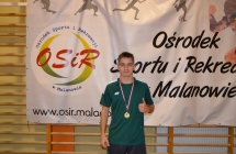 Marcel Kostrzewski wybrany zawodnikiem meczu na tle baneru OSiR Malanow