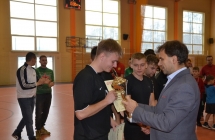 Mężczyzna wręczający puchar jednemu z zawodników drużyny piłkarskiej