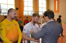 Uśmiechnięty mężczyzna odbierający medal od mężczyzny 