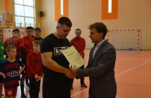 Mężczyzna wręczający dyplom piłkarzowi 