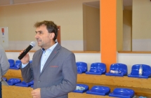 Mężczyzna mówiący do mikrofonu  na hali sportowej 