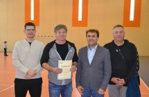 Czworo uśmiechniętych mężczyzn. Jeden trzyma dyplom, 