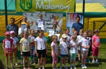 Trzy dziewczynki na podium. Obok nich inne uczestniczki biegu 