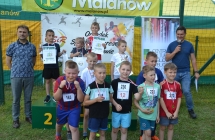 Chłopcy na trzech miejscach podium. Obok nich dwoje mężczyzn i kilkanaścioro chłopców z medalami 