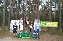 Troje mężczyzn na podium, dwoje reprezentantów władzy obok nich 