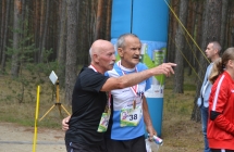 Dwoje mężczyzn patrzących w tym samym kierunku. Jeden pokazuje na coś w tle palcem 