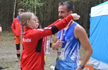 Dziewczynka nakładająca medal na szyję uczestnika biegu 