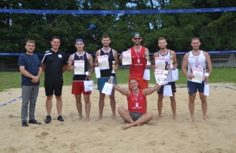 Kilku mężczyzn - zawodnicy drużyny plażowej piłki siatkowej 